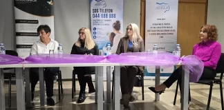 Četiri sudionice tribine sjede za stolom ispred panoa Centra za žene Adela.